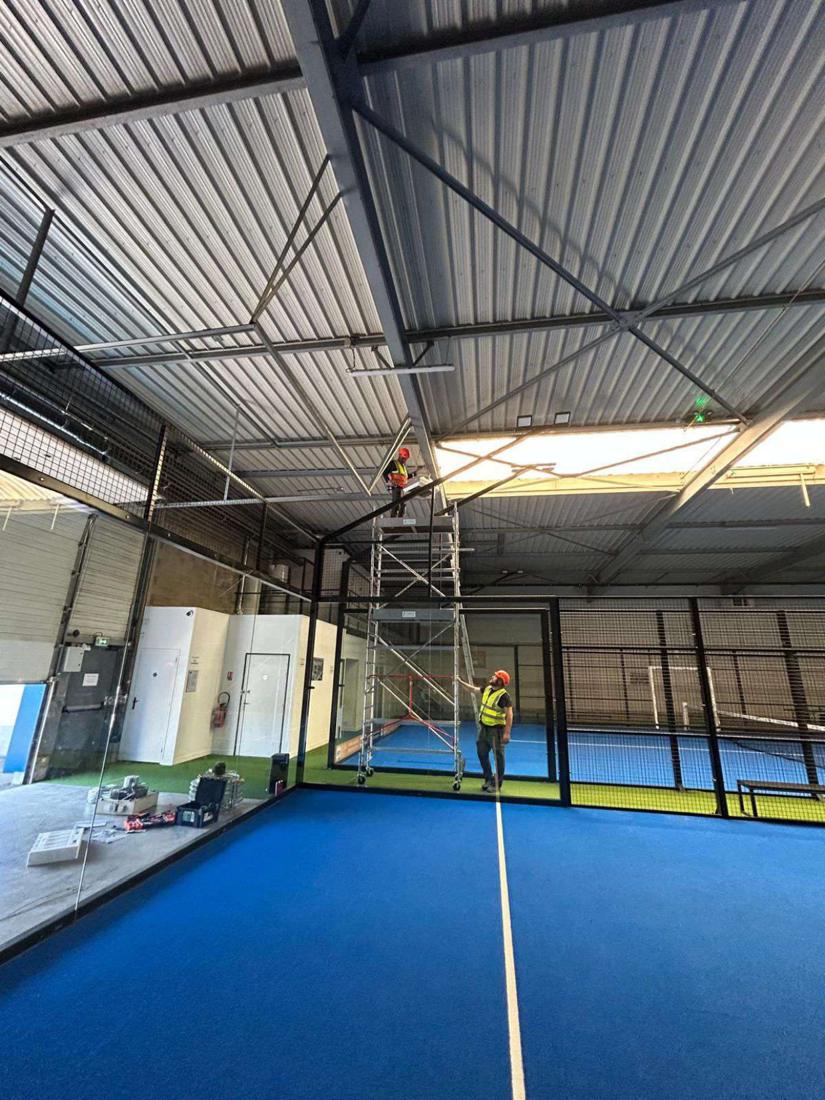 Salle de padel : Pose en hauteur, sur échafaudage, sans fermer la salle.